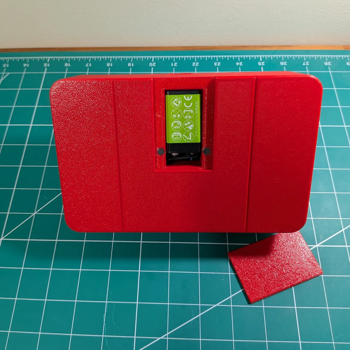 Back of the red Arcade Remote cabinet with its magnetic cover removed, showing the 9 V battery in its bay